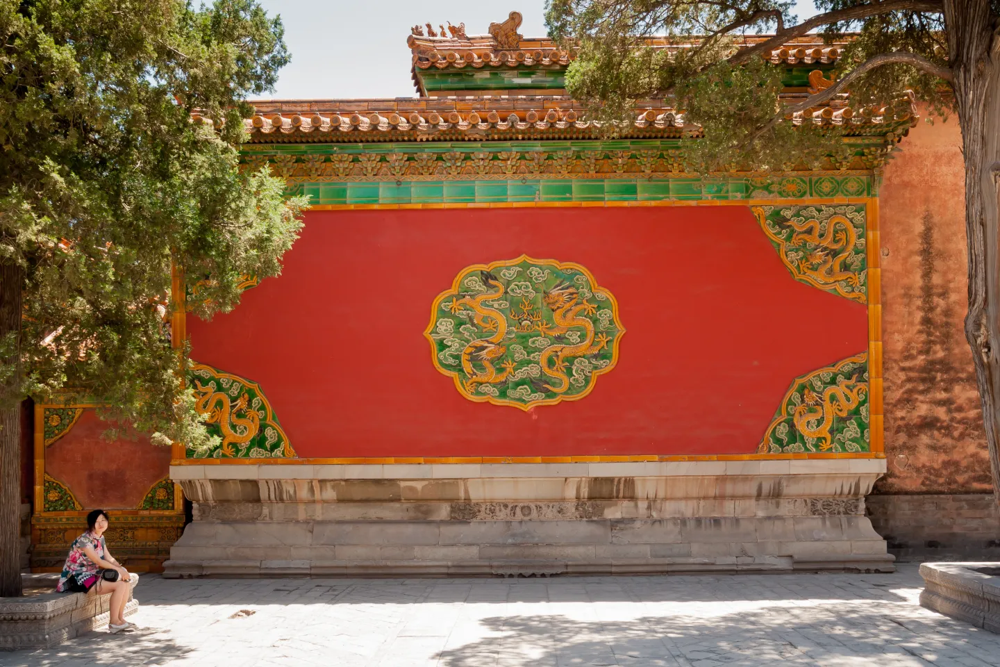 Green and gold dragon decoration on a red wall inside the Forbidden City